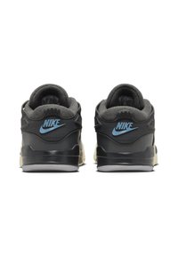 Sneakers in pelle nera con dettagli grigi, tacco sagomato e logo Nike blu, caratterizzati da una superficie texturizzata e una suola in gomma bianca.