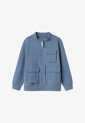 Chaqueta azul con cremallera, hecha de un tejido suave, que presenta un alto cuello, dos bolsillos frontales y puños acanalados en las mangas y el dobladillo.