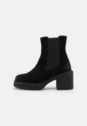 Botine negre din suede cu toc masiv și texturat, panouri laterale elastice și vârful rotunjit. Finisaj neted cu detalii de cusături subtile.
