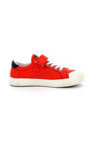 Zapatilla de lona roja con suela de goma blanca, cordones grises y correa ajustable de gancho y bucle. Presenta un acento en el talón en contraste azul marino.