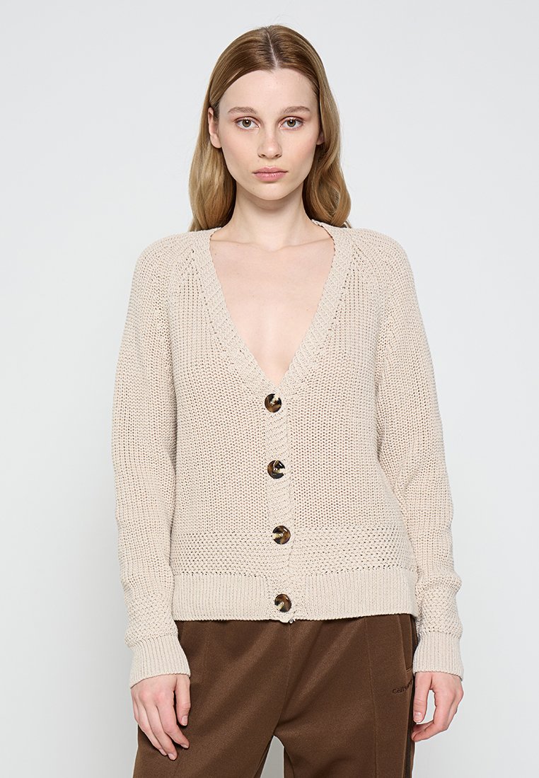 Beige gestrickte Strickjacke mit tiefem V-Ausschnitt, durchgehender Knopfleiste und gerippten Bündchen. Sie hat dekorative braune Knöpfe und ein lockeres, strukturiertes Design.