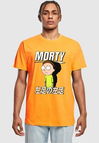 Narancssárga pamut póló, amelyen Morty, a mesefigura látható. A dizájn merész feliratokkal és kontrasztos színekkel rendelkezik, és laza fazonú.