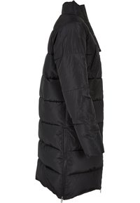 Cappotto puffo nero caratterizzato da un design lungo, cuciture orizzontali, tasche con zip e una texture liscia e lucida. Sono visibili aperture laterali con zip.
