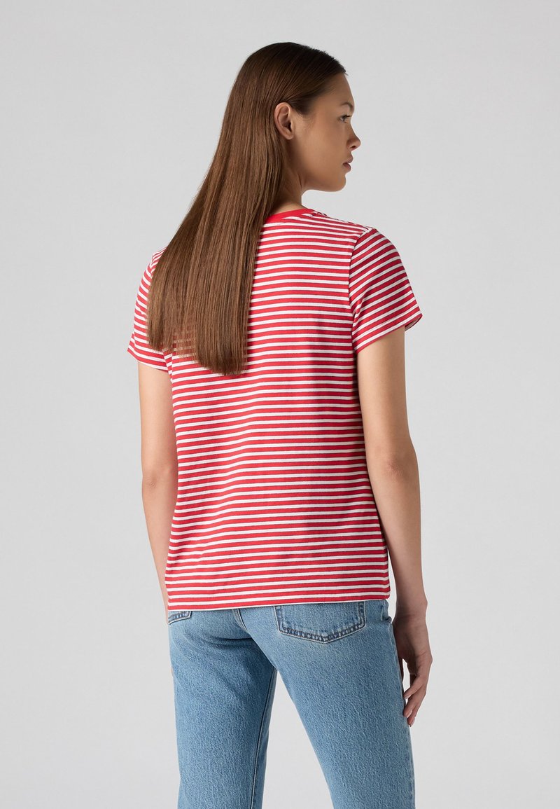 Rot-weiß gestreiftes kurzärmliges T-Shirt, Rundhalsausschnitt, weicher Baumwollstoff, klassische Passform, kombiniert mit hellblauen Jeans.