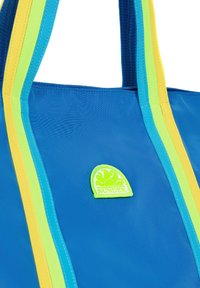 Borsa a tracolla blu con manici a strisce gialle e verdi. Presenta una patch con logo testurizzato raffigurante un sole e onde. Il materiale sembra durevole.