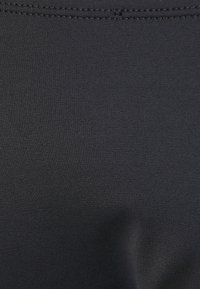Μαύρο ελασ�τικό ύφασμα με απαλή υφή και διακριτό ριγωτό σχέδιο. Διαθέτει ραμμένη ραφή κατά μήκος της πάνω άκρης για αυξημένη ανθεκτικότητα.