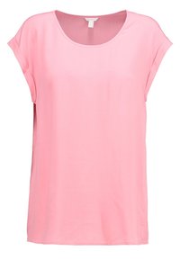 Top rosa a maniche corte realizzato in tessuto morbido, con scollatura tonda e vestibilità rilassata, dotato di spacchi laterali per facilitare i movimenti.