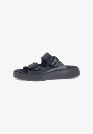 Zwarte slide sandalen hebben twee verstelbare riemen met gespen, een chunky platformzool en een gladde kunstlederen afwerking.