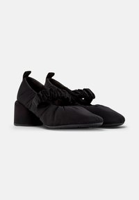 Scarpe in tessuto nero con un design arricciato nella parte anteriore, tacco basso a blocco e linguette per il sollevamento, caratterizzate da una texture liscia e una silhouette elegante.