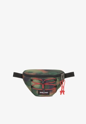 Camouflage-patterned fanny pack made of durable fabric, featuring a zip closure, red drawstring accents, and a black adjustable strap.
