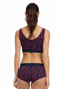 Navy blue bra and matching shorts set featuring pink floral patterns. Soft fabric with a smooth texture and elastic bands for support.