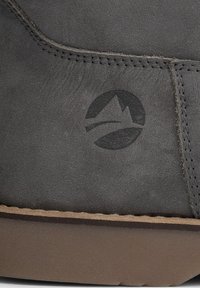 Šedá kožená bota s hladkým povrchem, mákulatým logem se způsobem hor a hnědou gumovou podrážkou. Přítomné prošívání.