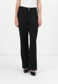 Zwarte, hooggeritste broek van zacht materiaal, met een sluiting aan de voorkant, rechte pijpen en een minimalistisch ontwerp.