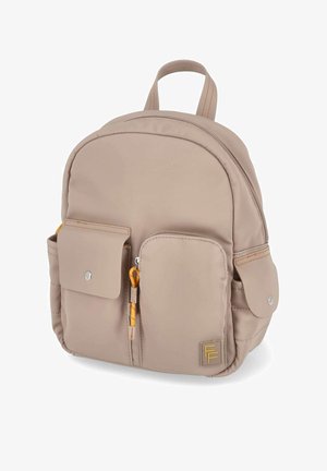 Small beige backpack with two front pockets—one with snap closure, one with zipper—and side pockets, featuring yellow zipper pull and logo patch.