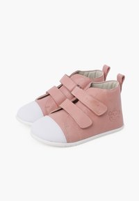 Scarpe per bambini in pelle rosa con punte in gomma bianca, dotate di due cinturini in Velcro, design low-top e un logo a forma di faccia di scimmia sul lato.