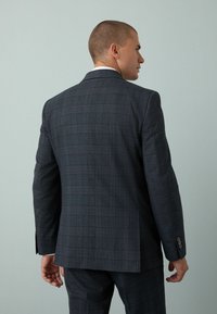 Sacou cu model în carouri gri închis, având un design structurat, cu guler tăiat și mansete cu nasturi. Material neted, cu o croială ajustată.