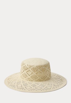 Plačiais kraštais smėlio spalvos šiaudinė skrybėlė su austiniu raštuotu dizainu ir plokščiu karūnos viršumi, rodoma ant šviesaus, paprasto fono.