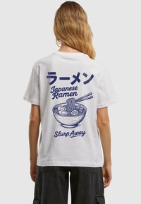 Bílá tričko s modrou grafika, na které je miska ramen, hůlky, japonský text a fráze "Slurp Away". Krátké rukávy.