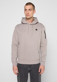 Lichtgrijze hoodie van zachte stof met een buidelzak, verstelbare trekkoorden en een ritszak op de linker mouw. Zeshoekig logo op de borst.