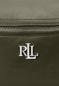 Zelená kožená taška se zipovým uzávěrem, s výrazným stříbrným logem "RLL". Hladký povrch s viditelným prošíváním podél okrajů.