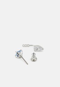 Orecchini in argento con diversi componenti: uno zircone cubico blu, una pietra trasparente a forma di pera e un ulteriore pezzo di chiusura tondo.