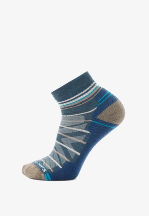 Knöchelsocken mit einem geometrischen Muster in Grau, Blau und Beige. Aus gestricktem Baumwollmaterial mit verstärkter Zehen- und Fersenpartie.