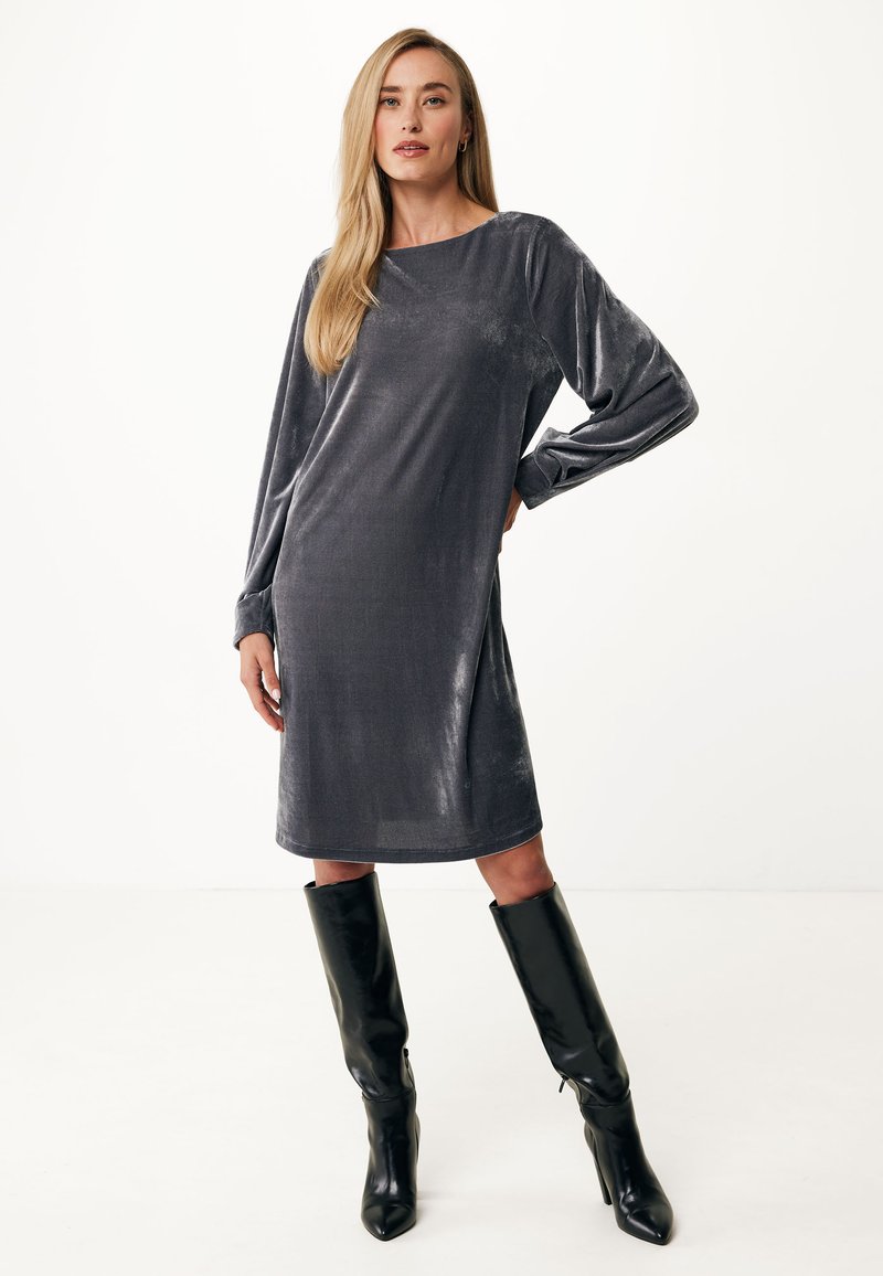 Graues samtweiches Langarmkleid mit Bootsausschnitt, das knapp über dem Knie endet, kombiniert mit schwarzen kniehohen Stiefeletten mit Absatz.