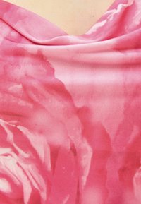 Tissu rose à texture lisse avec un motif doux de roses aquarelles. Le design drapé crée des plis délicats et une apparence fluide.