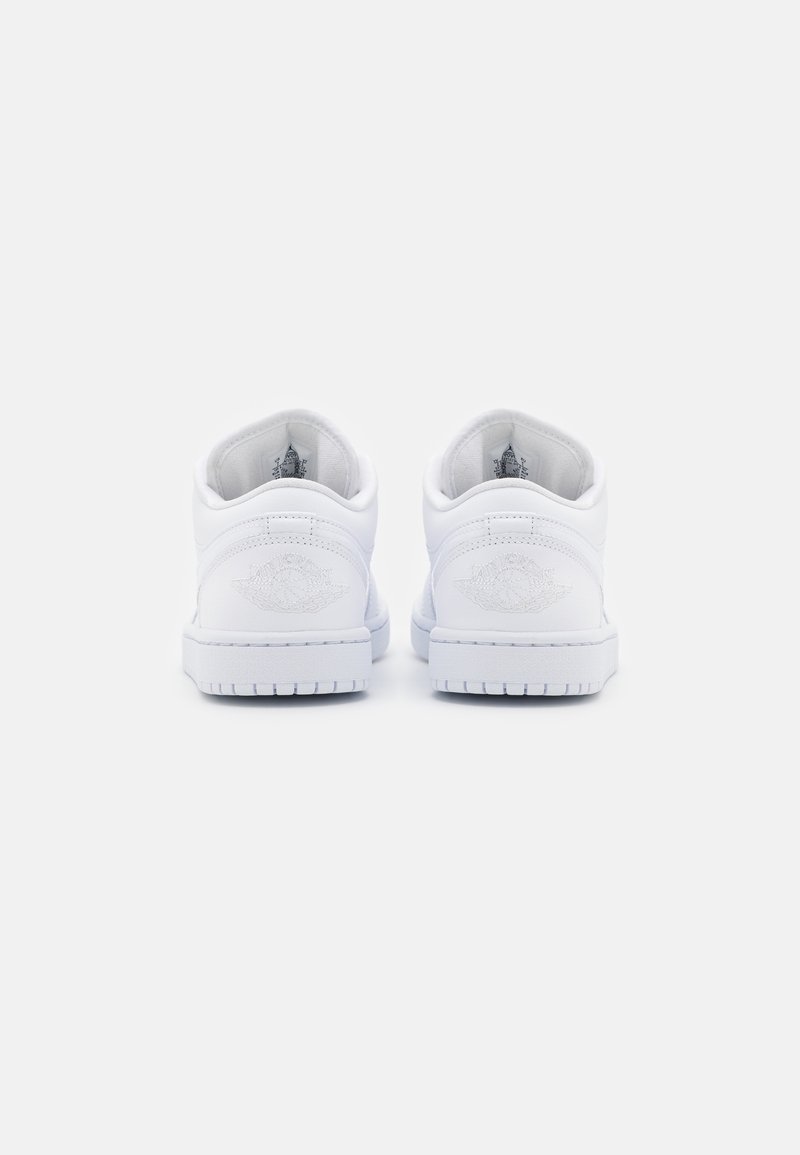 Des baskets blanches en cuir présentent un design basse avec un talon texturé, des accents de logo brodés et une semelle en caoutchouc avec des motifs de traction.