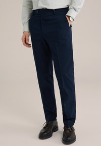 Pantaloni de marină dintr-un material texturat, cu închidere cu buton, buzunare laterale și o croială ajustată. Purtați cu pantofi închisi la culoare.