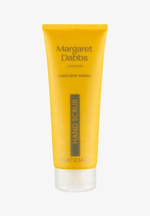 Tube jaune avec un couvercle à charnière, finition texturée, étiquetée "GOMMAGE POUR MAINS." Lettres grises comprenant "Margaret Dabbs" et "MAINS FABULEUSES."