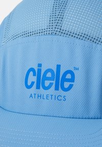 Light blue athletic cap with mesh panels, textured fabric, and "ciele ATHLETICS" logo in blue on the front panel.