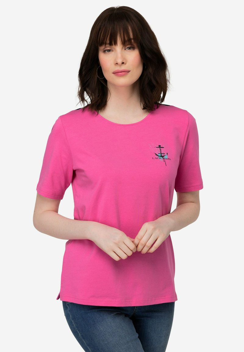 Roze T-shirt met korte mouwen van zacht materiaal, met een ronde halslijn en een kleine ankerafbeelding met tekst op de linkerborst.