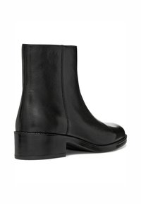 Bottine en cuir noir avec une texture lisse, bout rond et un petit talon empilé. Présente un design minimaliste et des lignes épurées.