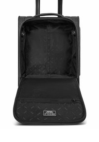 Maleta de tacto suave negra con asa extensible, abierta para mostrar el compartimento principal vacío y un bolsillo de malla con cremallera en el interior de la solapa frontal.