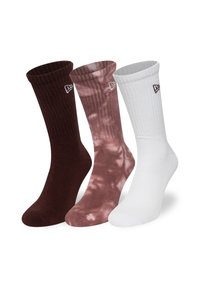 Tre par ankelsockor: mörkbruna, ljusrosa tie-dye och helt vita. Varje par har ribbat mudd och liten logotyp på sidan.