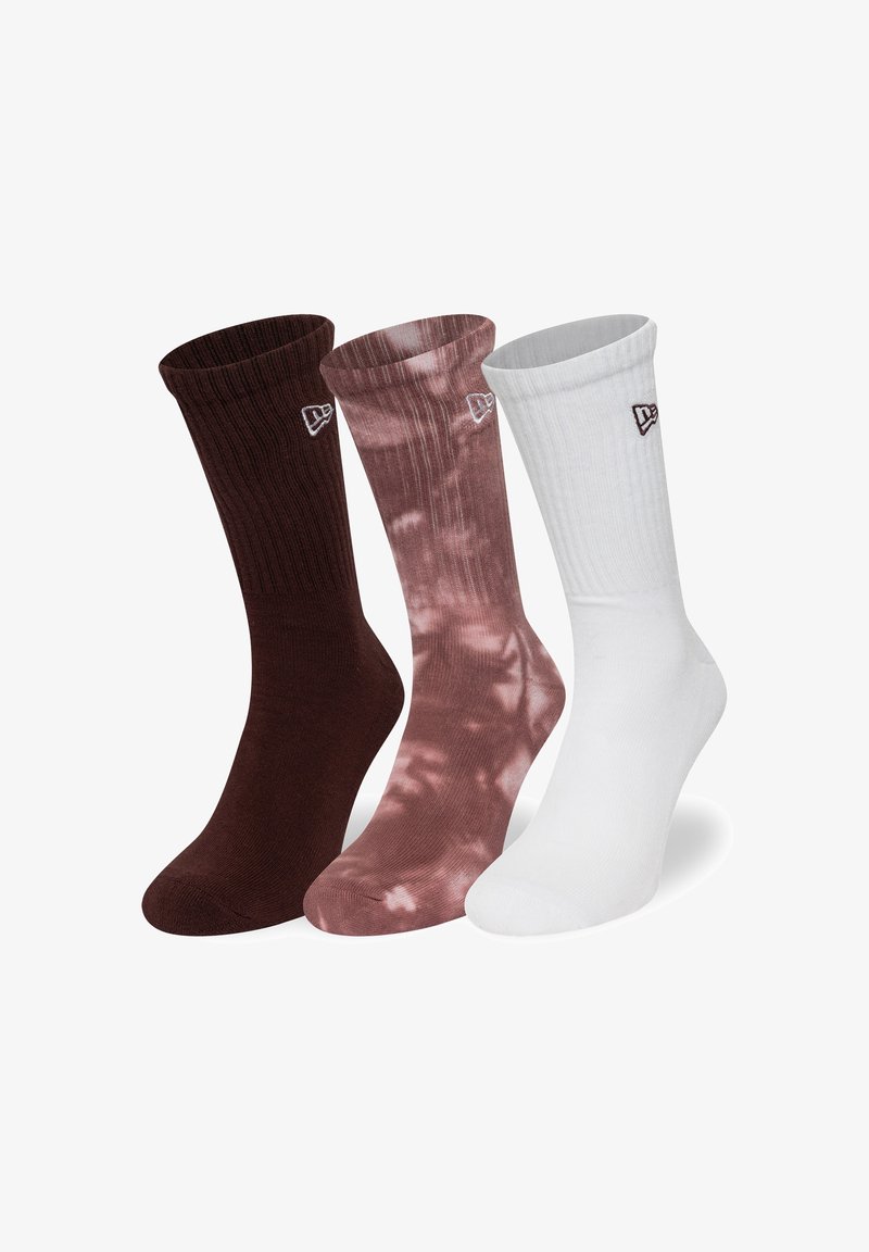 Tre par ankelsockor: mörkbruna, ljusrosa tie-dye och helt vita. Varje par har ribbat mudd och liten logotyp på sidan.