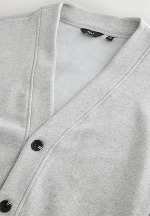 Jasnoszary kardigan wykonany z miękkiego materiału, z dekoltem w szpic, z czarnymi guzikami i gładką fakturą, idealny do warstwowego noszenia.