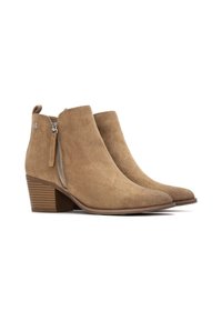 Botas de ante marrón hasta el tobillo con punta afilada, cremallera lateral y tacón apilado. Cuentan con una tira de tiro en bucle y un sutil detalle de marca.