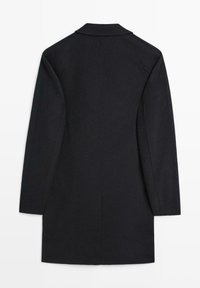 Cappotto lungo nero con una texture liscia, taglio dritto, colletto a rever, e maniche lunghe, con una cucitura centrale sul retro.