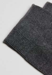 Calza grigia a coste con una texture morbida, presenta una leggera lucentezza e un risvolto rinforzato per una maggiore durata.