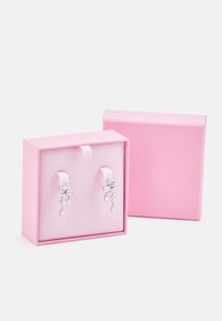 Orecchini a goccia in cristallo trasparente, presentati in una scatola rosa, caratterizzati da un design a grappolo con forme e dimensioni miste, montati su perni bianchi.