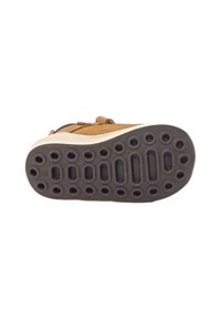Scarpa in pelle marrone con suola in gomma dotata di ritagli circolari e ovali per una migliore aderenza. Cinghia regolabile per la chiusura, dettagli beige sulla suola.