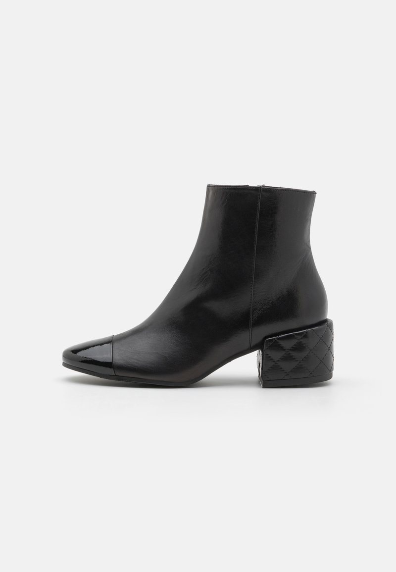 Sorte skinn ankelboot med spiss tå, blankhette og kviltet blokkhæl-design. Glatt tekstur med en slank silhuett.