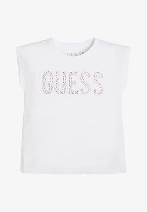 Débardeur blanc avec épaules matelassées et "GUESS" écrit en strass roses sur la poitrine.