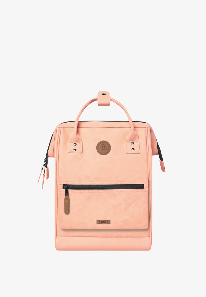 Peach-colored backpack made of soft material features a top handle, front zipper pocket, and a logo patch. Includes accent hardware details.