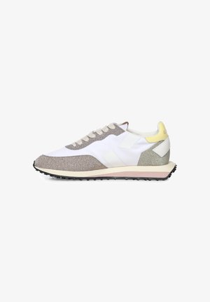 Vue latérale d'une chaussure de sport blanche et beige à lacets, avec une semelle texturée et un accent jaune au niveau du talon.