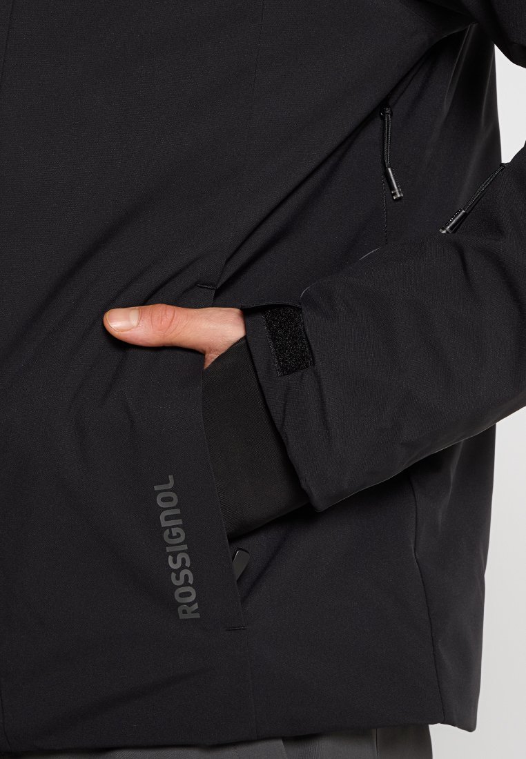 Schwarze, wetterfeste Jacke mit einem Reißverschlusstasche, Klettverschluss-Akzenten und Logodetail an der Seite. zeichnet sich durch eine glatte Textur und eine schmale Passform aus.