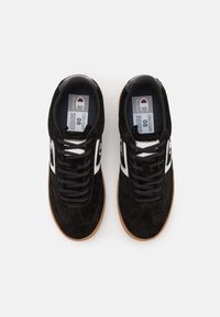 Sneakers negre din suede cu accente albe, având o talpă din cauciuc, design cu șireturi și căptușeală din material moale. Eticheta de dimensiune vizibilă în interior.