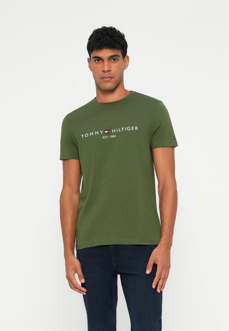 Grøn bomulds-t-shirt med rund halsudskæring, korte ærmer og logo print i hvid og farver på brystet. Casual fit.